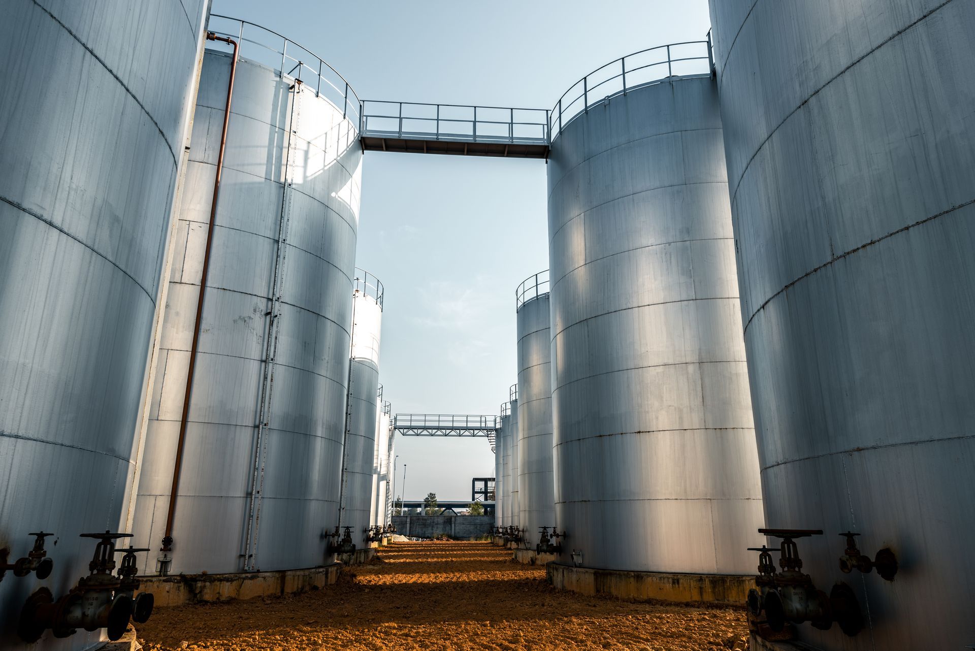 Large stainless steel storage tanks at a manufacturing facility requiring professional confined-space tank cleaning services
