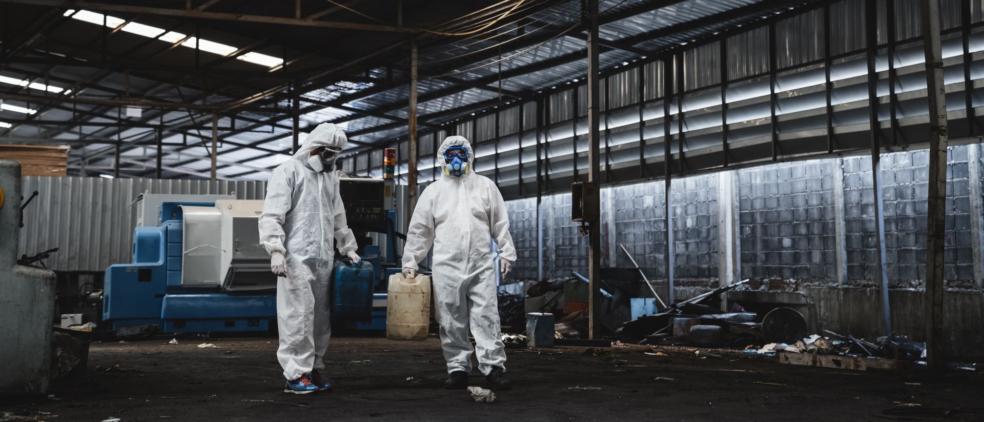 Hazmat technicians in protective suits inspecting and handling chemicals during regulated hazmat services