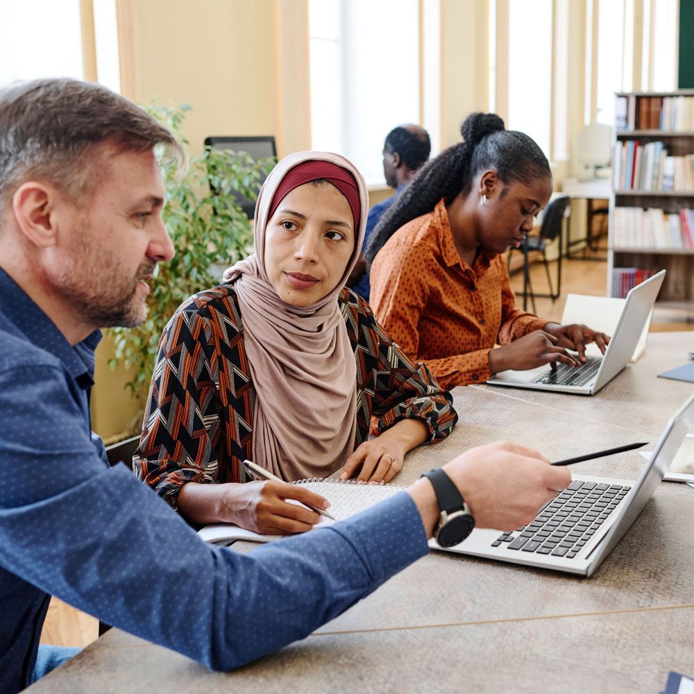 Teacher with student on laptop
