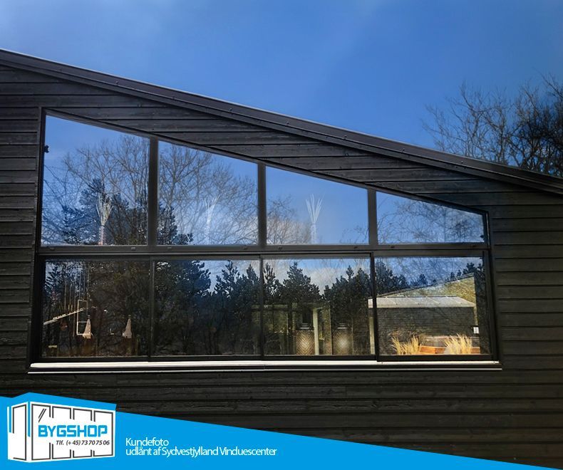 Uderum med skydevinduer i aluminium og glas, set udefra.
