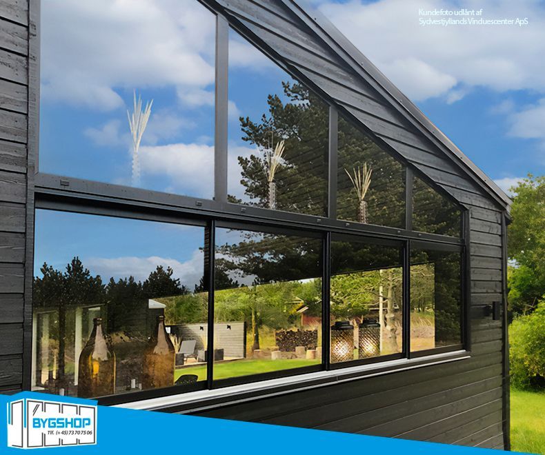 En udestue med BS-skydevinduer og fastkarm i aluminium og glas. Set udefra.