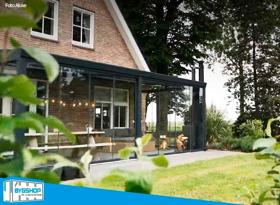 Trendline overdækning i RAL Antracitgrå struktur. Udestuen har monteret rammeløse skydedøre. Foto Aluxe