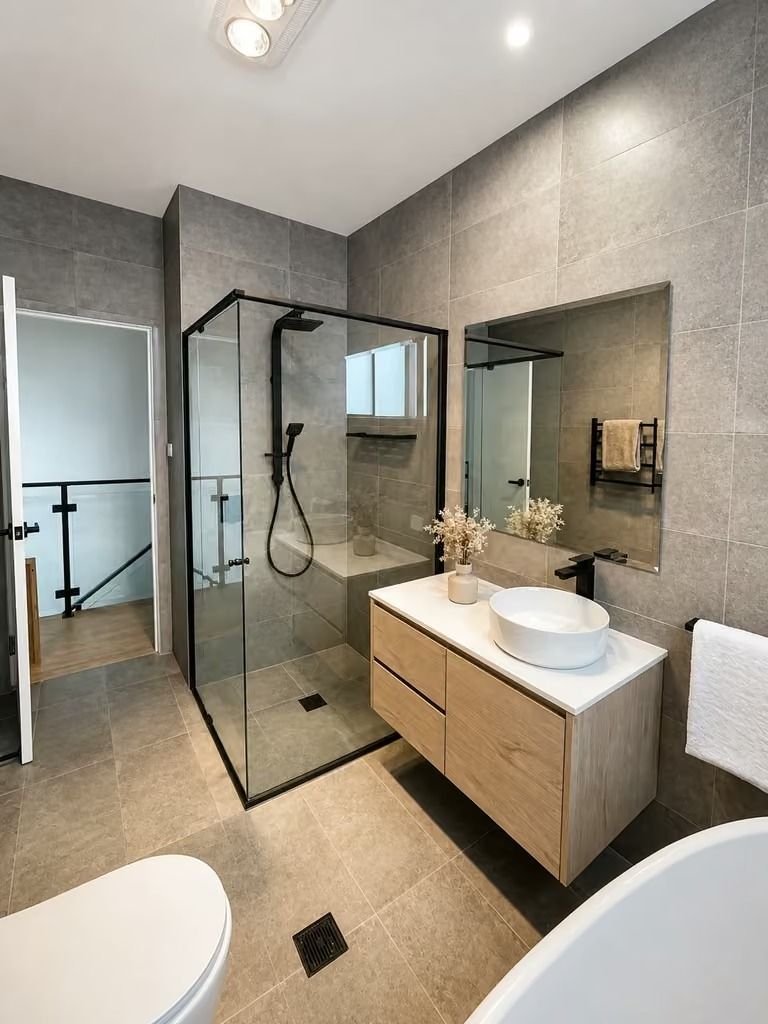 Modern gray bathroom with glass shower, floating wood vanity, and large mirror