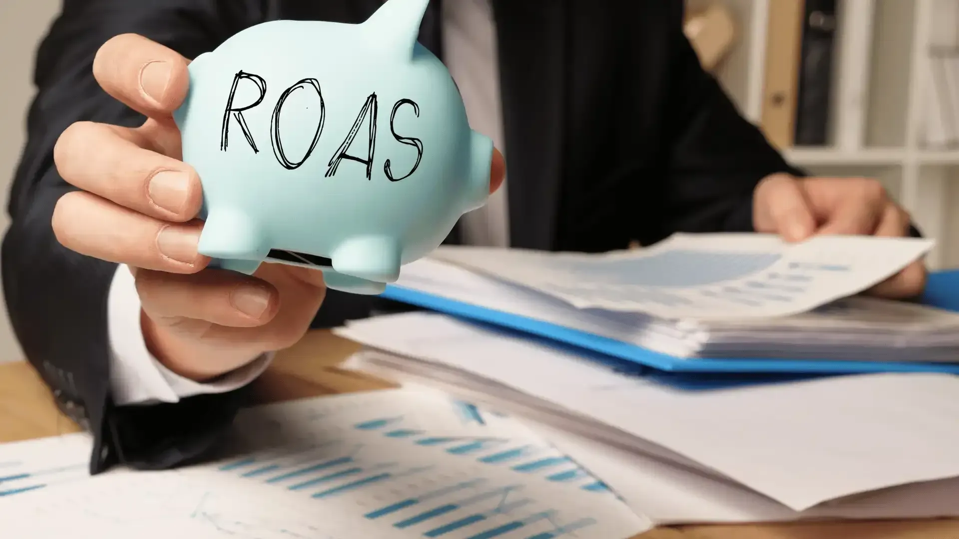 a person holding a piggy bank that says roas