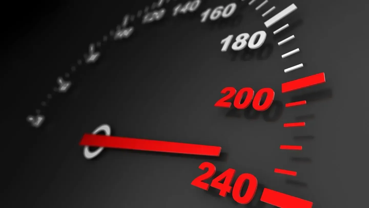 A speedometer with a red arrow pointing to the number 240