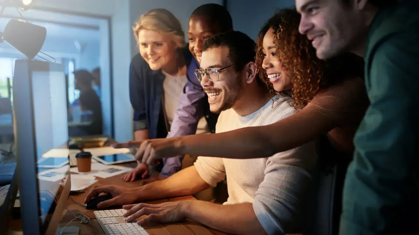 A group of people are looking at a computer screen together.