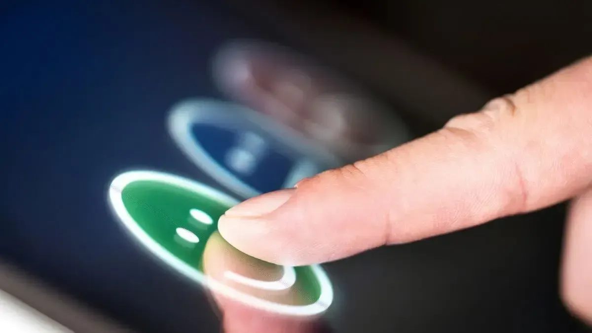 A person is pressing a button on a tablet with their finger.