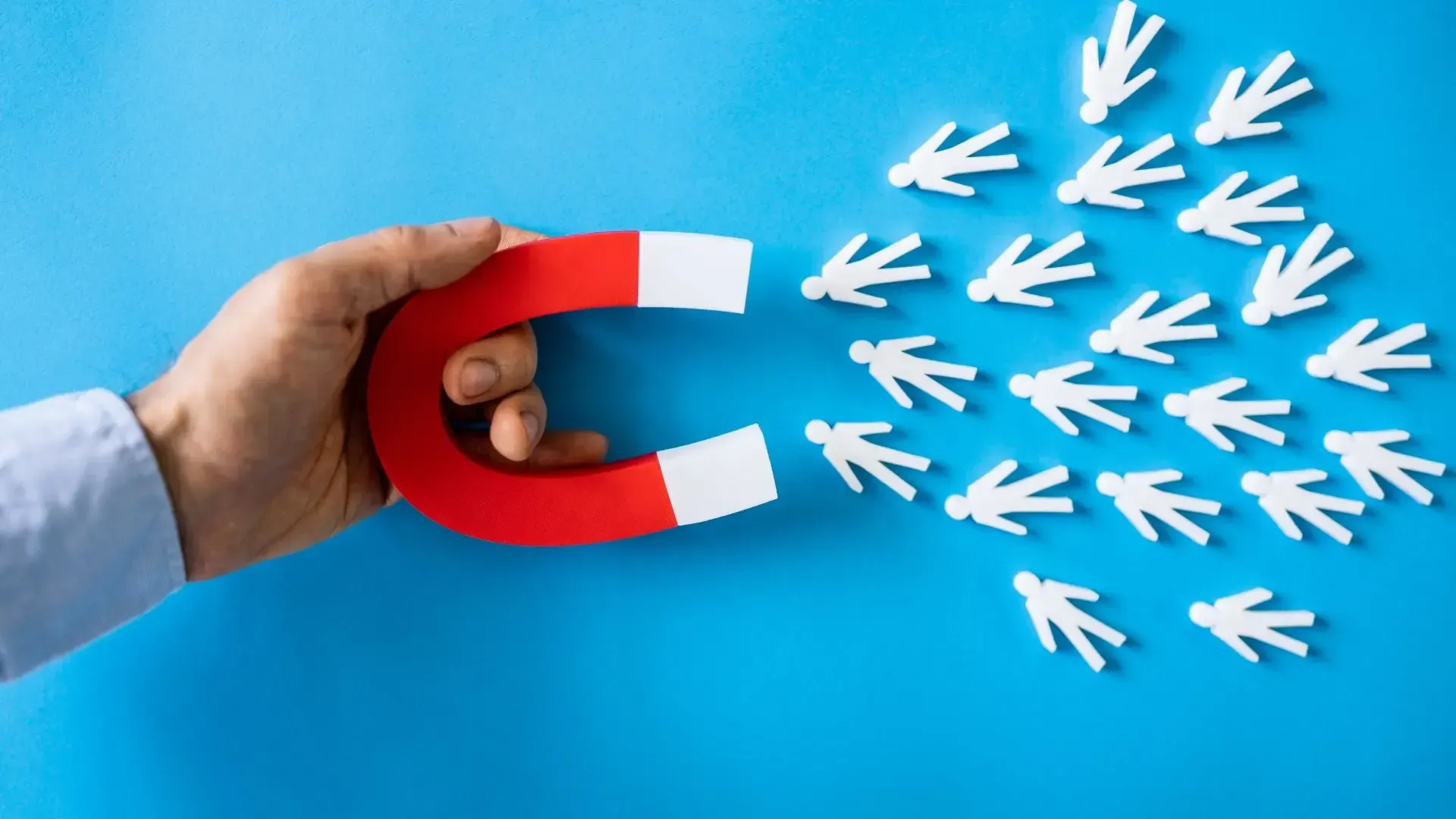 A person is holding a red and white magnet in their hand.