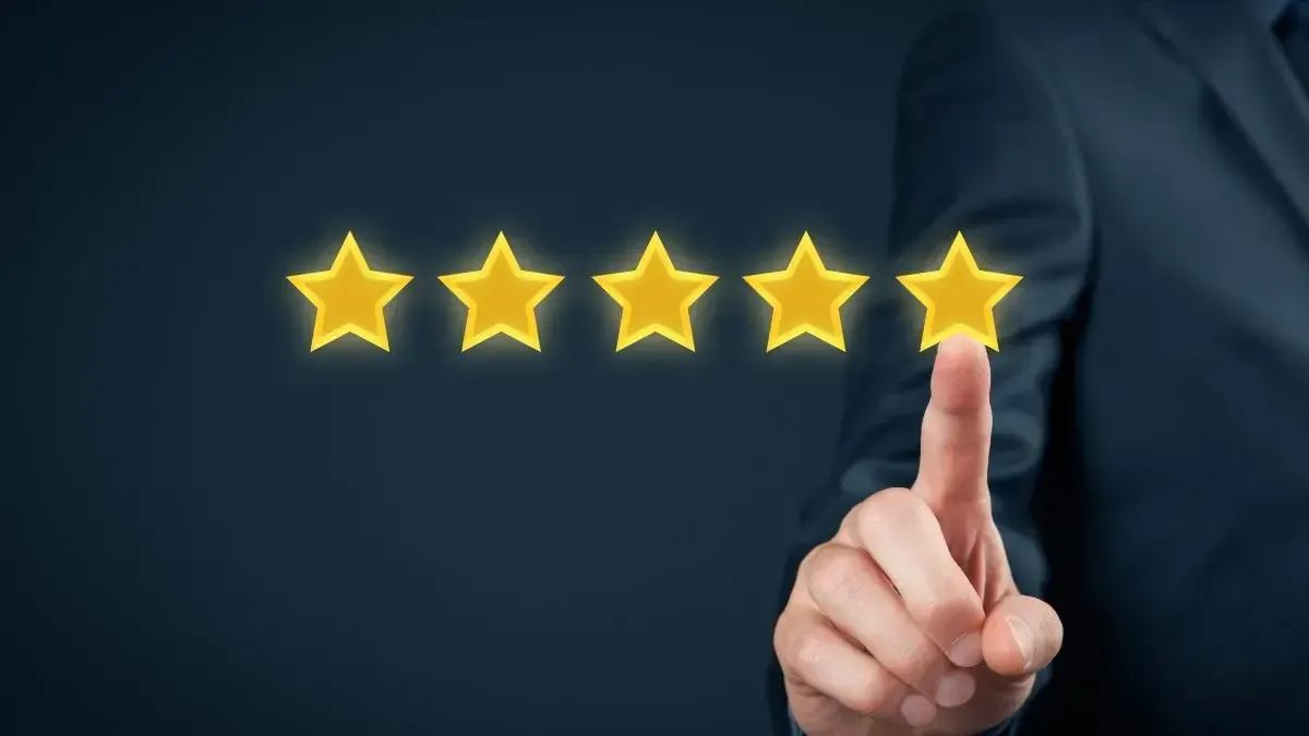 A person is pointing at five stars with their finger.