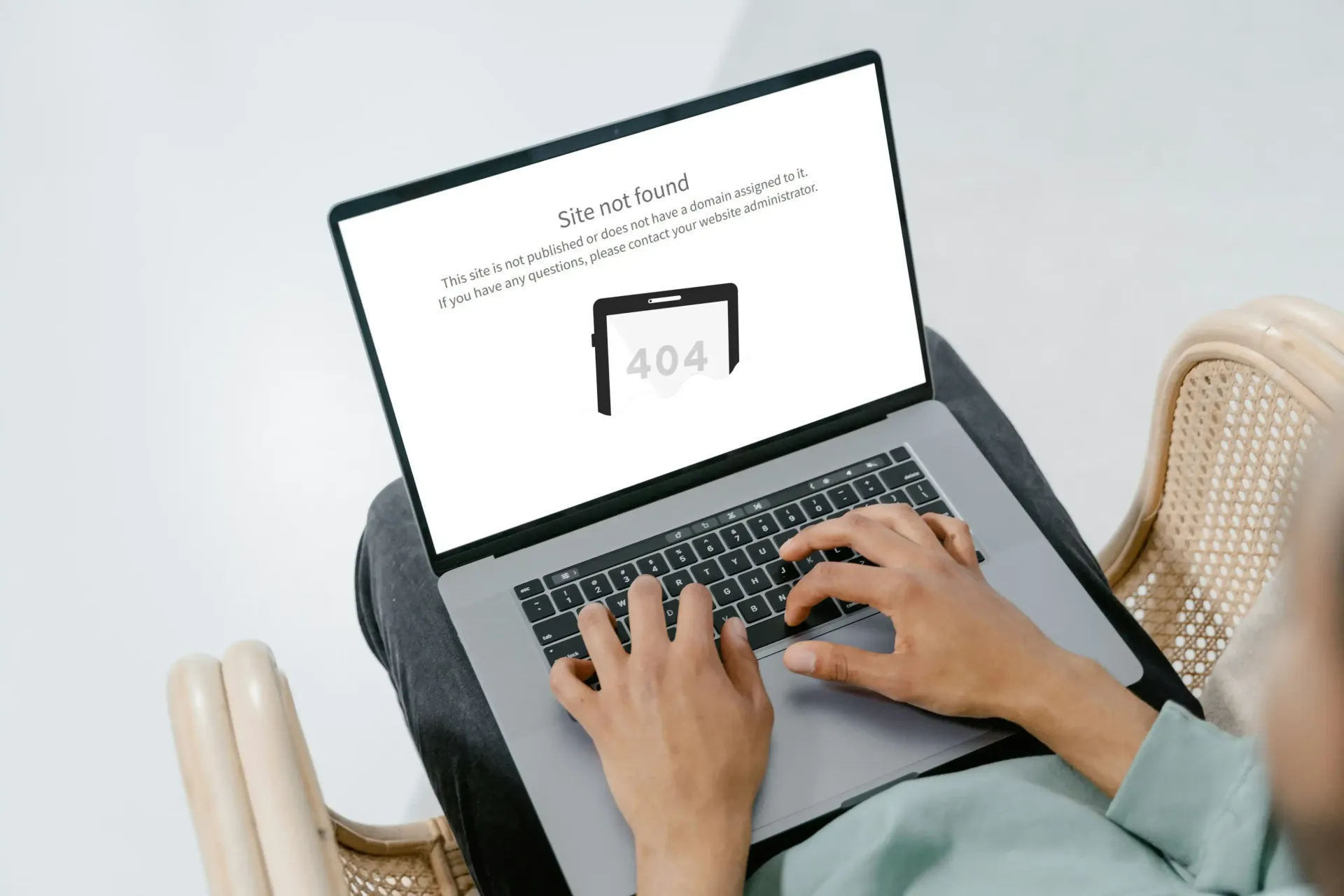 A person is typing on a laptop computer with a 404 error on the screen.