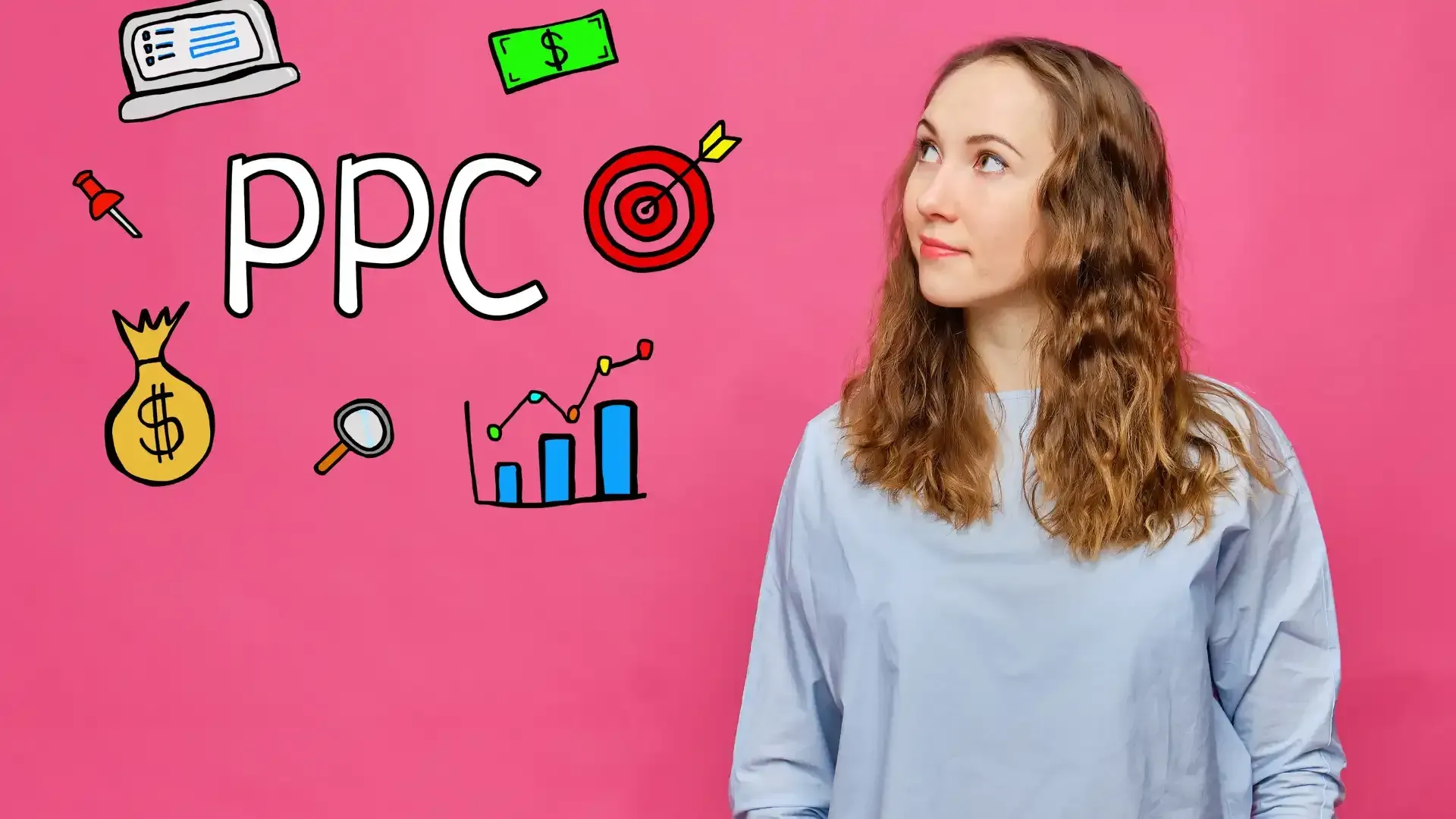 A woman is standing in front of a pink wall with drawings on it.
