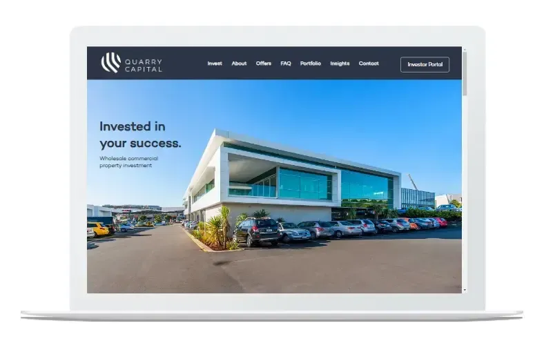A laptop computer is open to a website that says invested in your success.