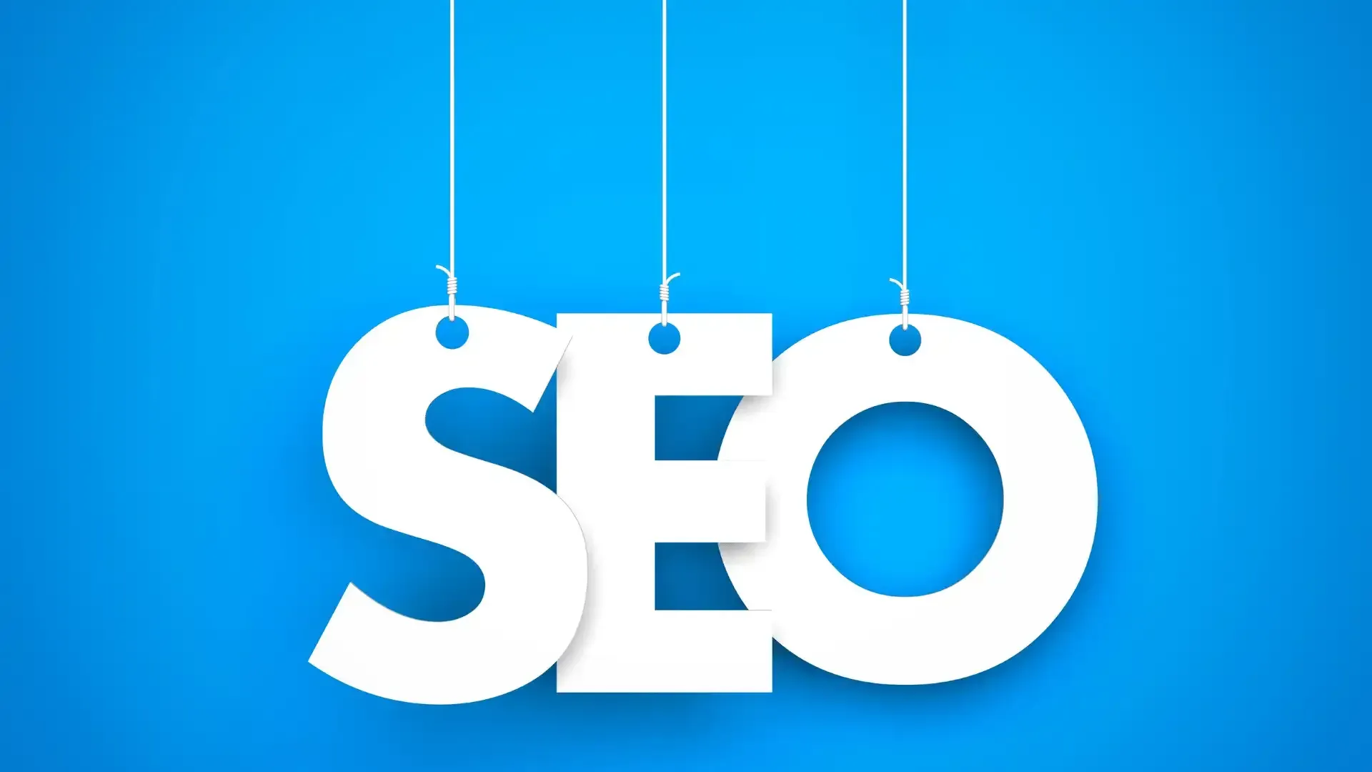 the word seo is hanging from strings on a blue background