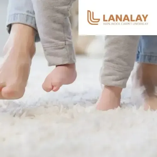 Close-up of bare feet of child and adult on a fluffy white wool carpet; Lanaly logo in the corner.