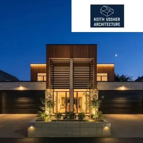 Modern luxury home exterior at dusk with warm lighting and Keith Ussher Architecture logo above
