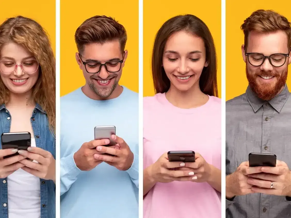A group of people are looking at their cell phones.