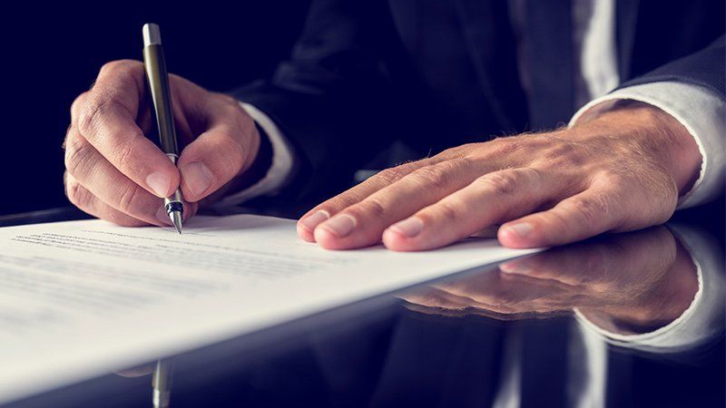 man writing on a piece of paper
