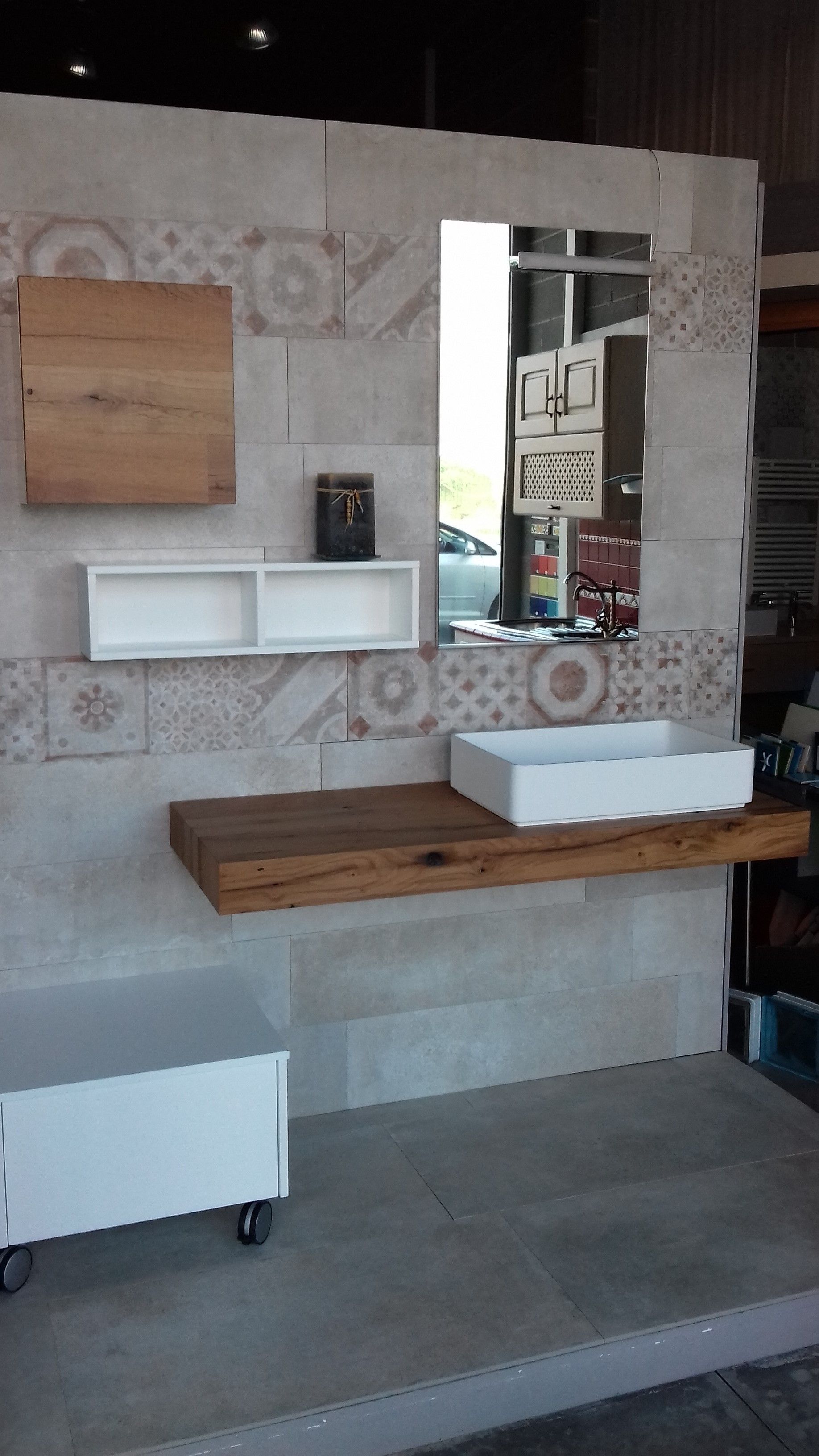 Un bagno con un lavandino e uno specchio sul muro.