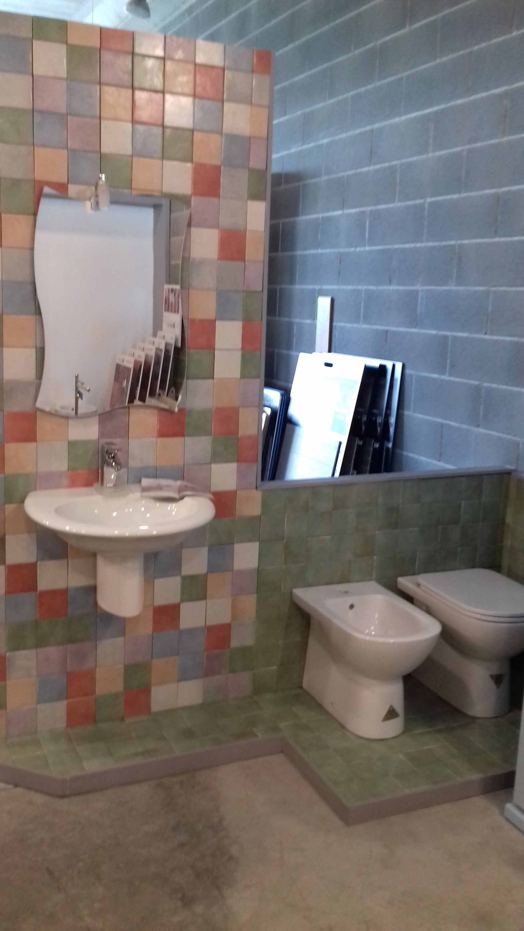 Un bagno con un lavandino, un water e uno specchio