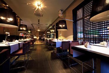 A long dining room with tables and chairs in a restaurant.