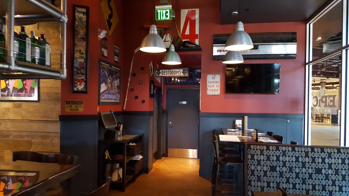 A restaurant with a red wall and a green exit sign