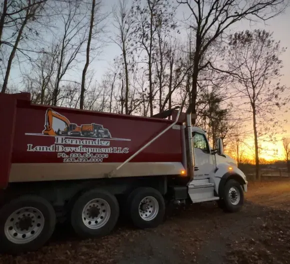 A red dump truck with the word land development on it
