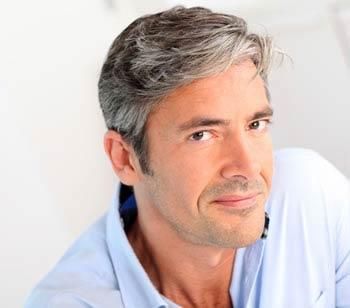 Uomo di profilo con capelli grigi folti e naturali: risultato dell'autotrapianto FUT Strip per la ricrescita dei capelli