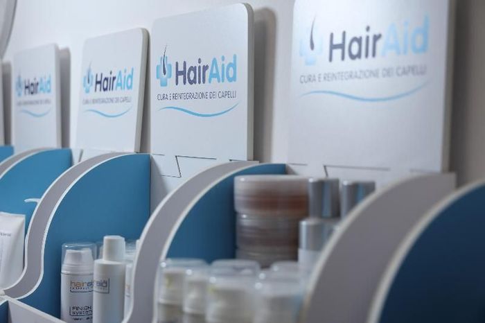 Staff HairAid in studio con materiale informativo sui trattamenti per la perdita dei capelli