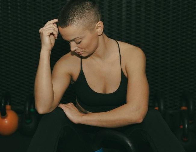 Donna con capelli rasati che medita: tricopigmentazione femminile per l'alopecia