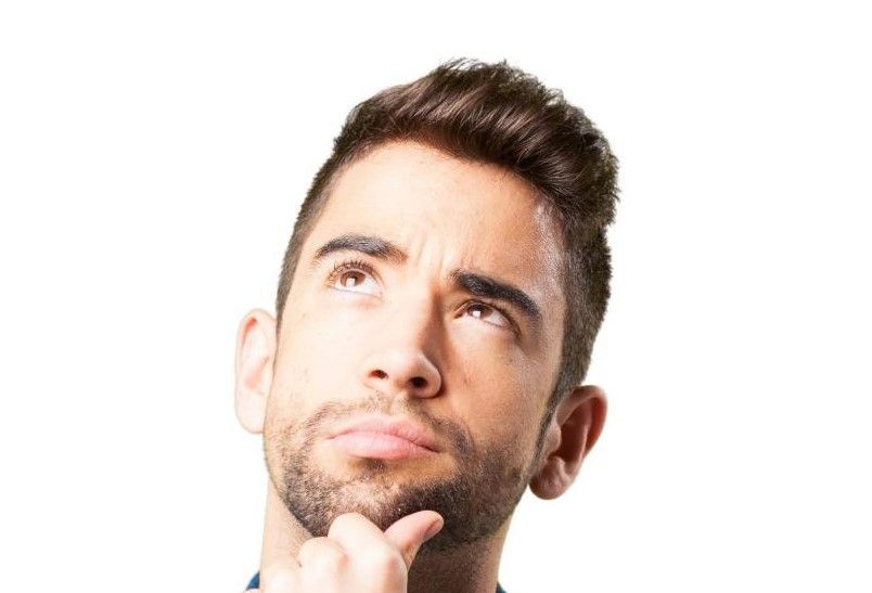 Uomo riflessivo che valuta il momento giusto per il trapianto di capelli: guida alla decisione