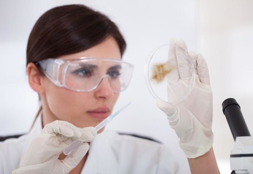 Professionista in camice e occhiali che analizza campioni per il test mineralogramma del capello