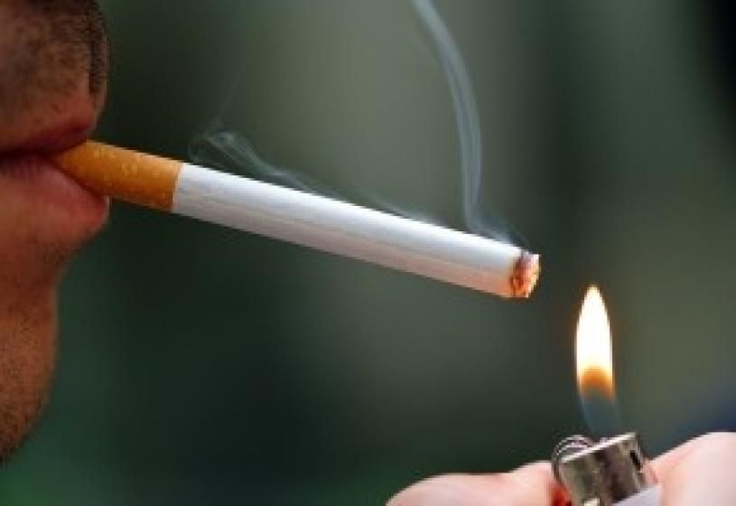 Persona che accende una sigaretta: il fumo come fattore di rischio per la caduta dei capelli