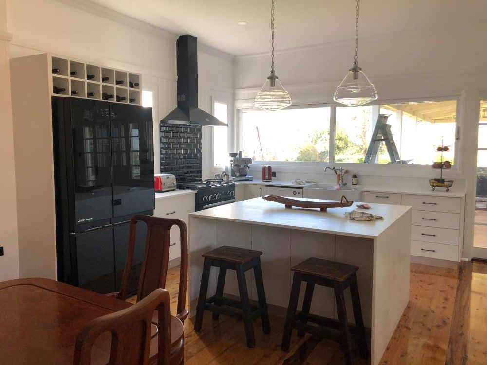 A Kitchen With a Large Island , Stools , a Table and a Refrigerator — 4Shaw Kitchens in Nyngan, NSW