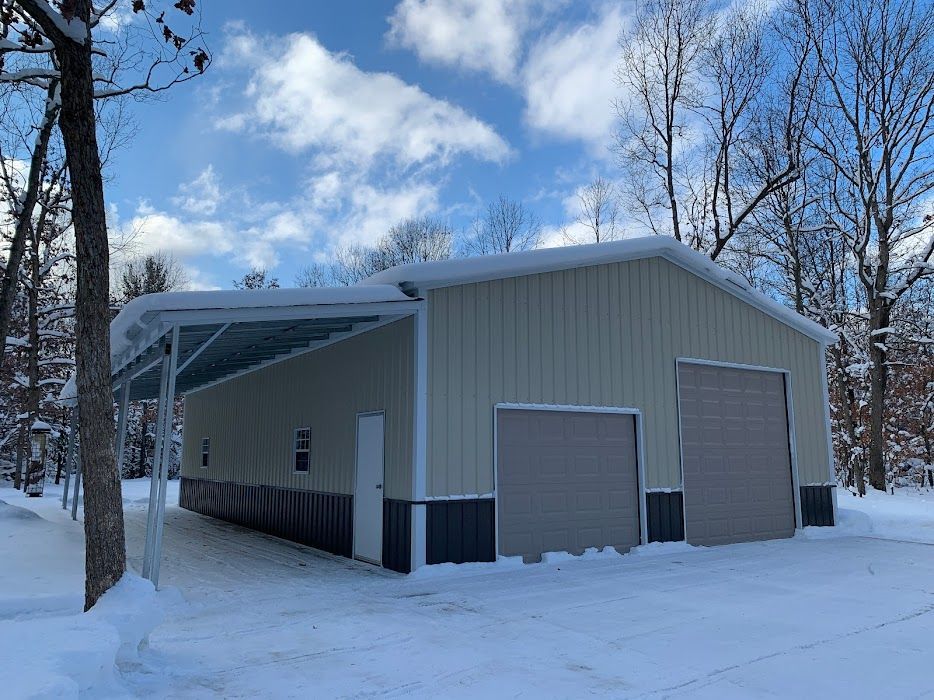 a large metal building with a canopy is covered in snow .