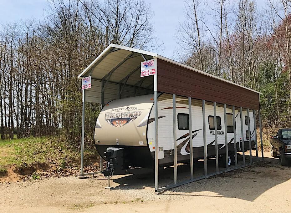 a trailer is parked under a canopy in a parking lot .