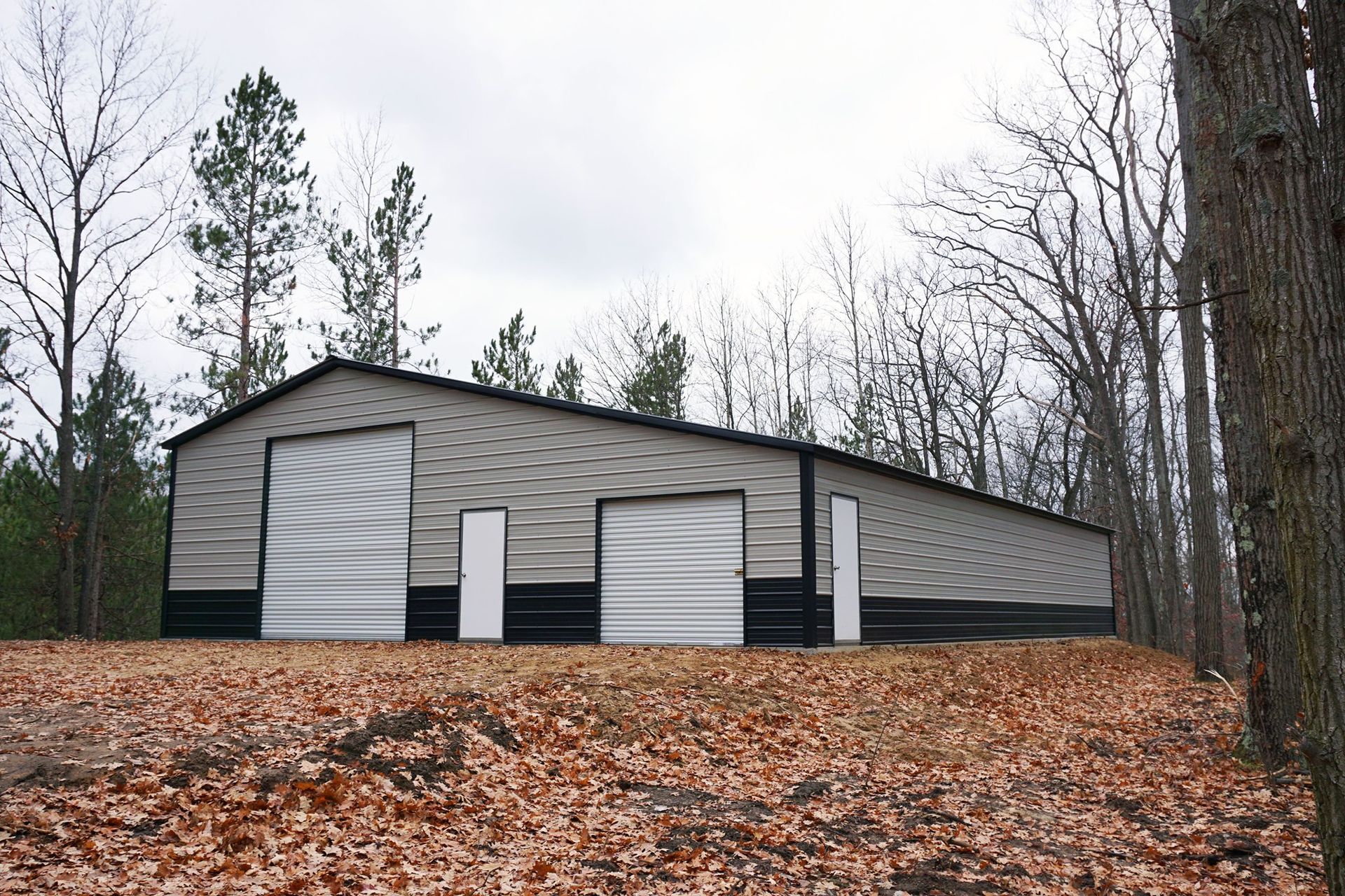 a large metal building is surrounded by trees and leaves
