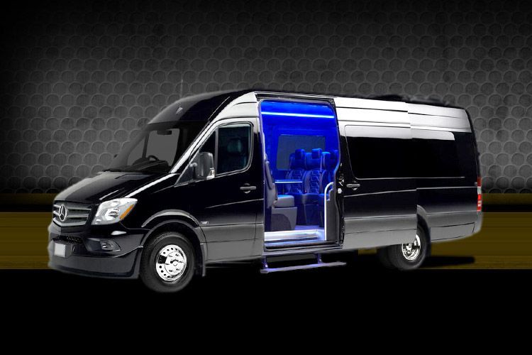 Black passenger van with sliding side door open, revealing blue-lit interior.
