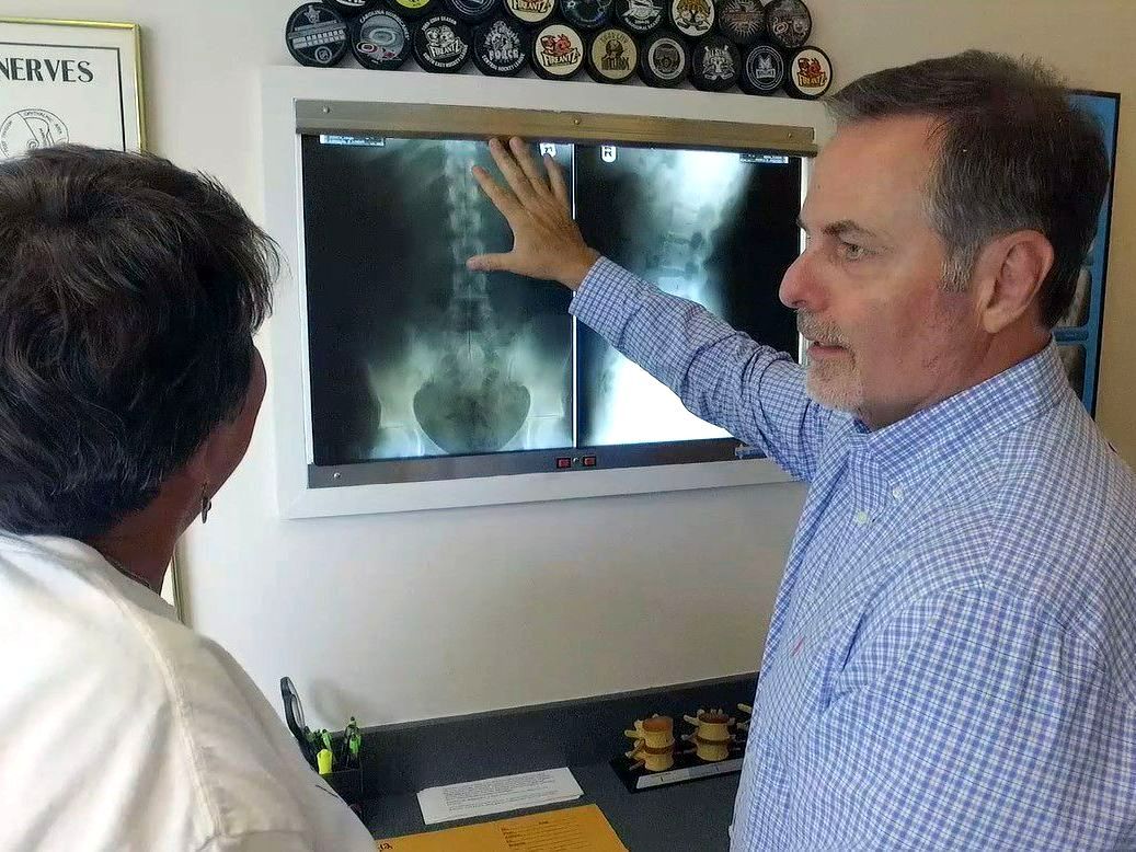 Two people examining X-ray films on a lightbox in a medical office in Fayetteville, NC