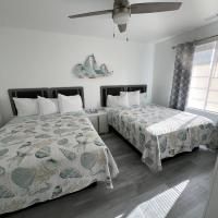 A hotel room with two beds and a ceiling fan.