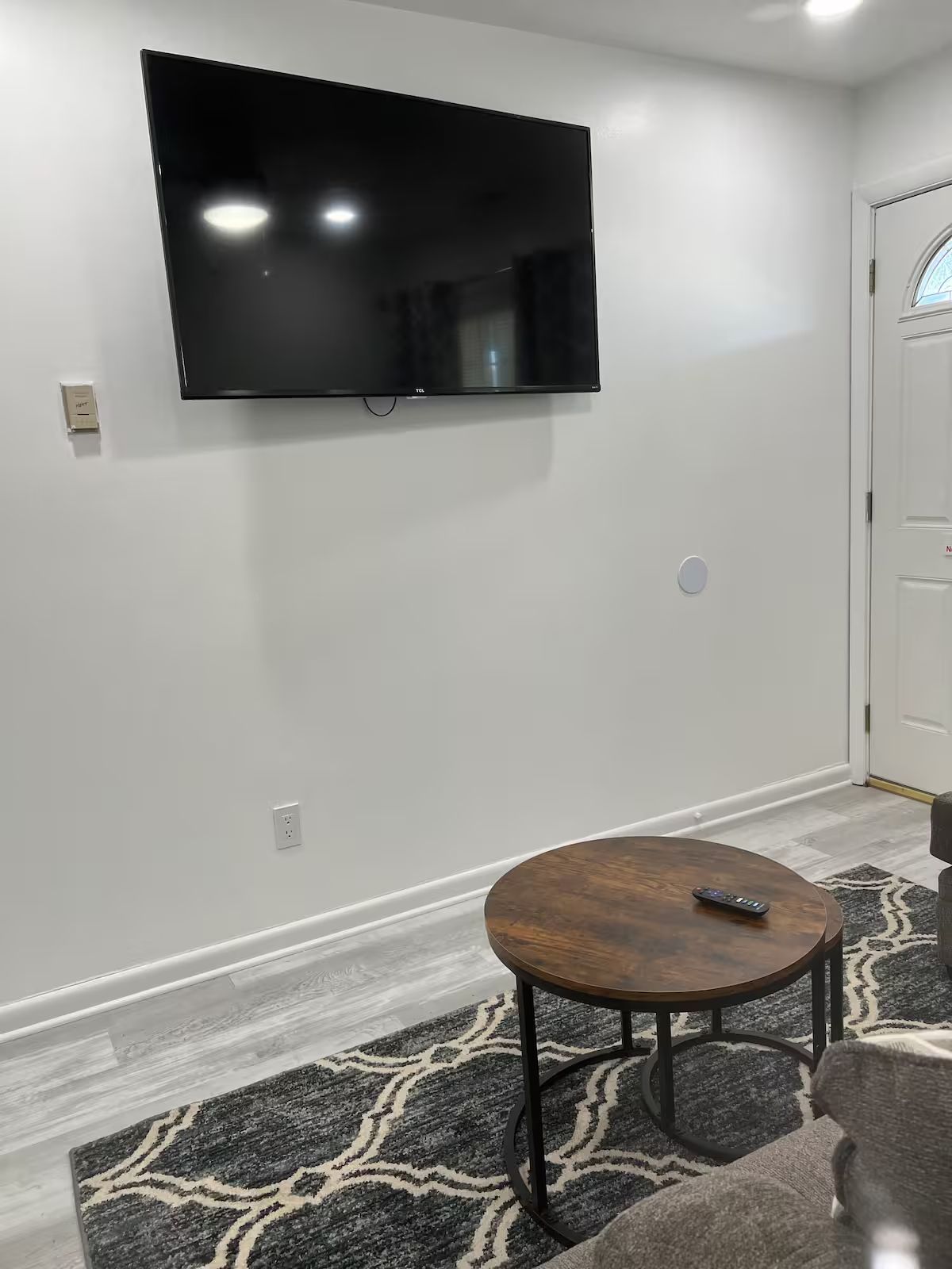 A living room with a large flat screen tv mounted on the wall.