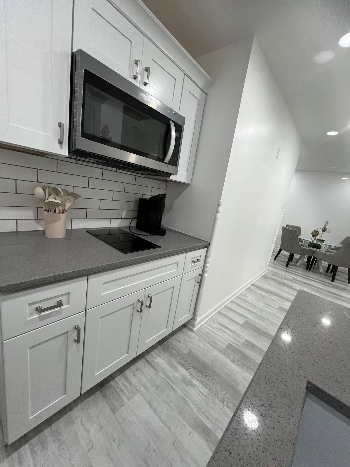 A kitchen with white cabinets and stainless steel appliances