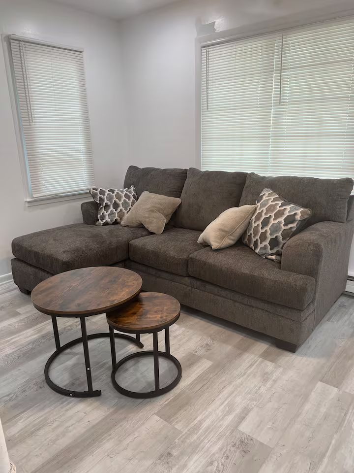 A living room with a couch and two coffee tables.