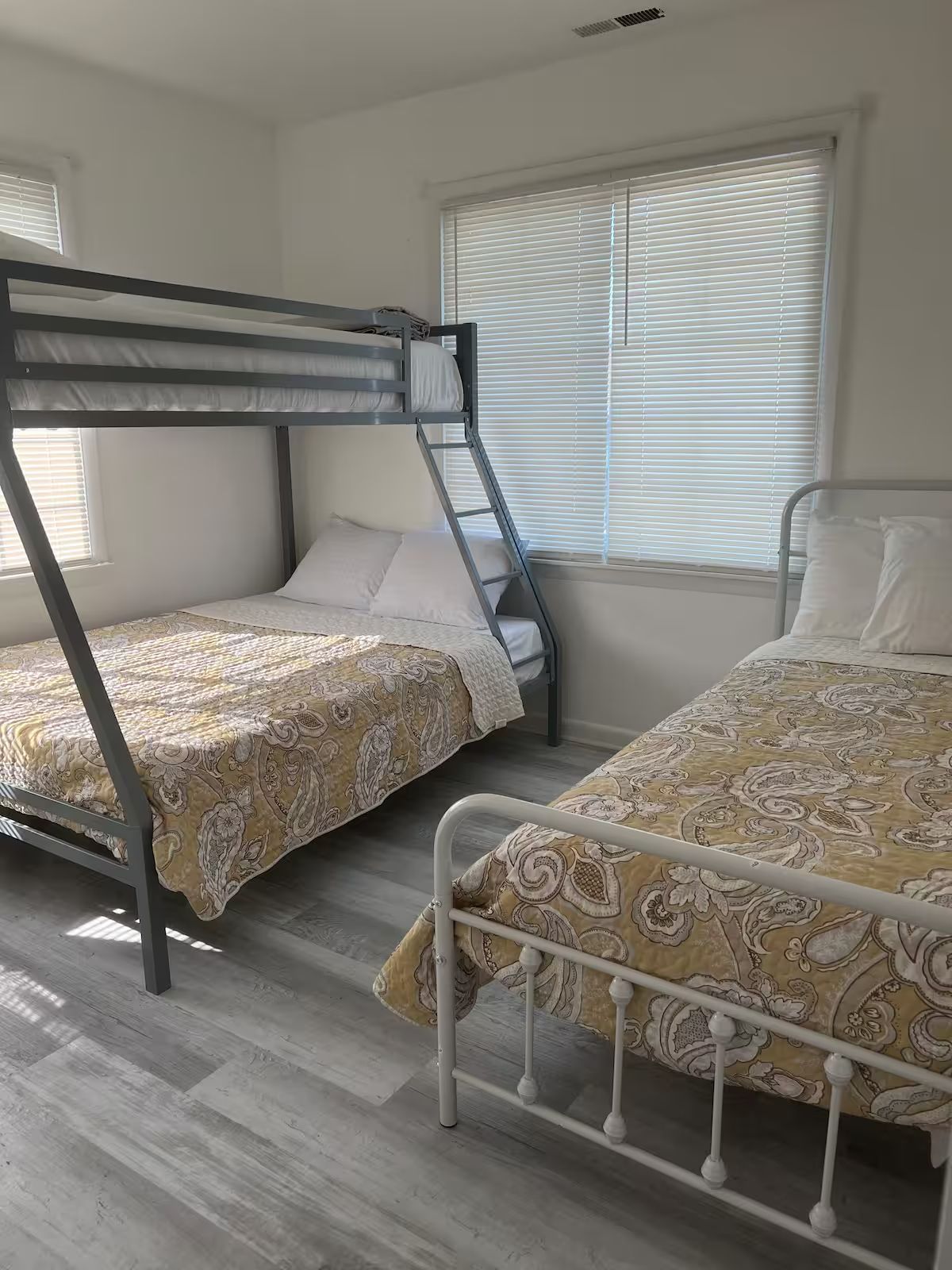 A bedroom with two bunk beds and a single bed.