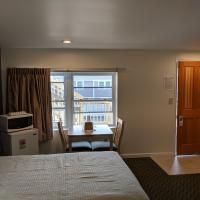 A hotel room with a bed , table and chairs.