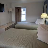 A hotel room with two beds , a television and a window.