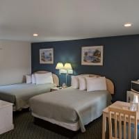A hotel room with two beds , a table and chairs.
