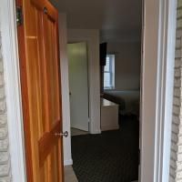 A doorway leading to a bedroom with a bed and a window.
