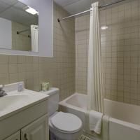 A bathroom with a toilet , sink , bathtub and shower curtain.