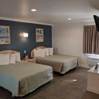 A hotel room with two beds and a flat screen tv.