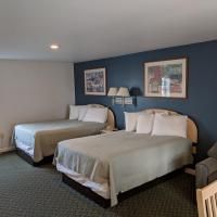A hotel room with two beds and a chair.